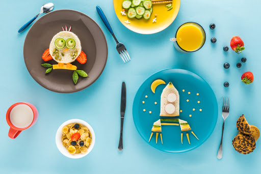 flat lay with creatively styled children's breakfast on colorful tabletop